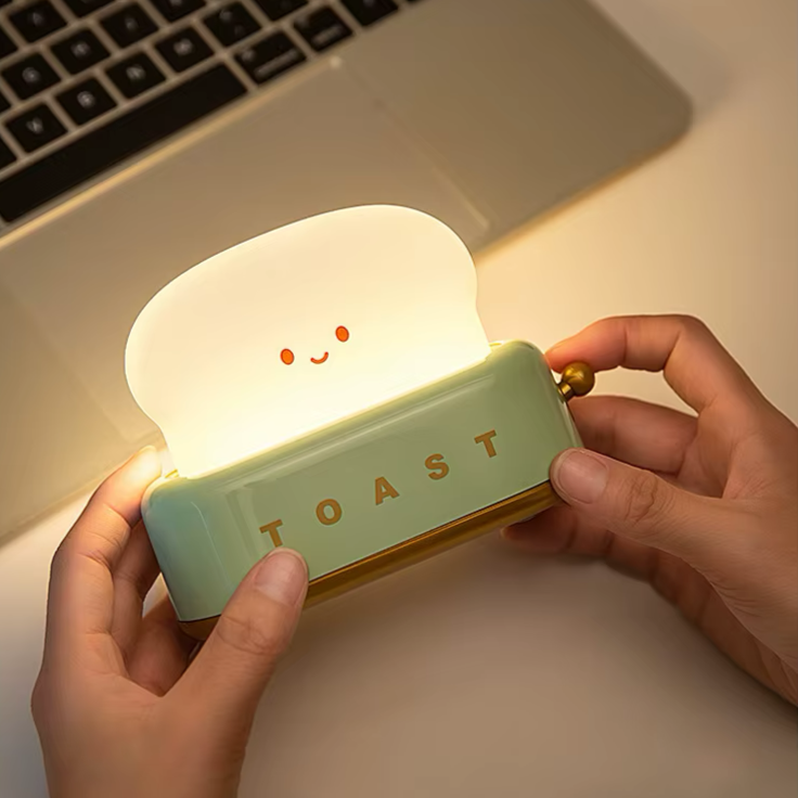 Portable toaster-shaped night light, ideal for flexible use in bedrooms or workspaces. Provides a soft and warm glow, available at BlissfulGlow.